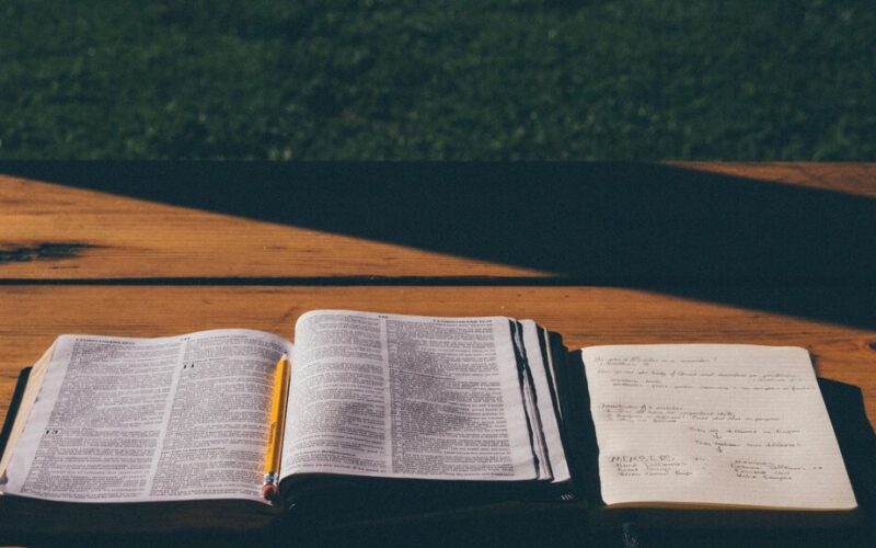 Open bible table sunlight on